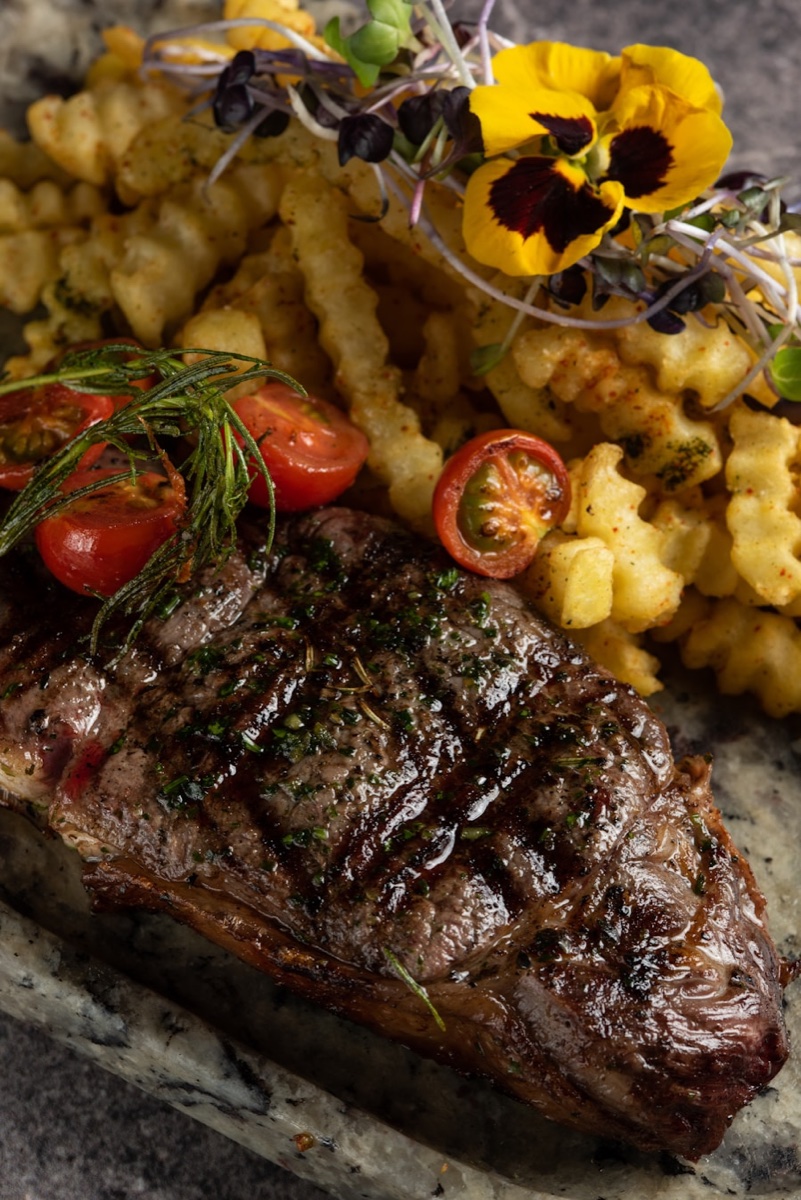 Grilled steak with roasted potatoes and greens